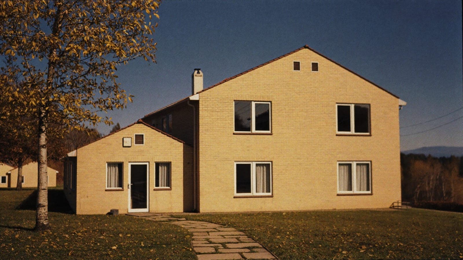 Gult tegelhus från 1960-talet i höstsol